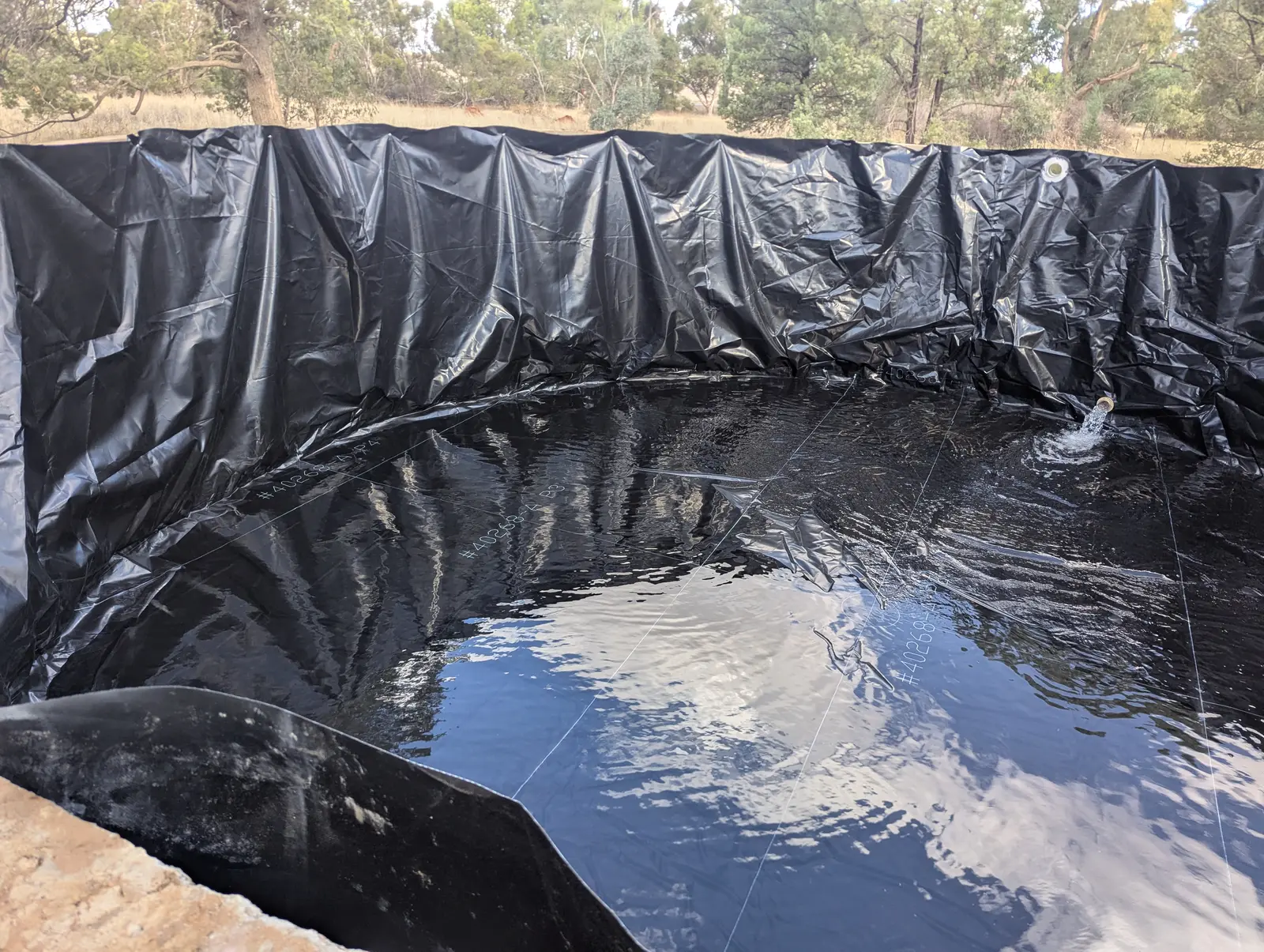 Concrete tank fitted with a new liner, refilling with water