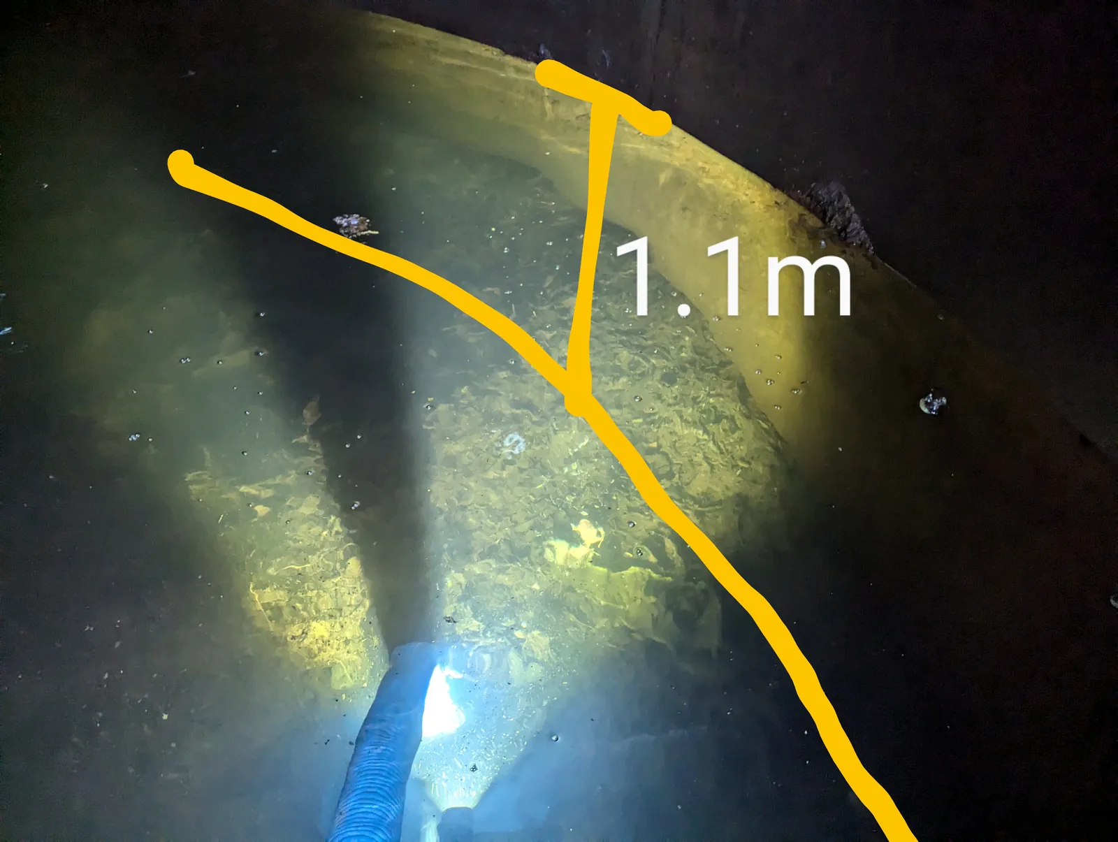 Sludge floating in a concrete water tank before vacuum cleaning